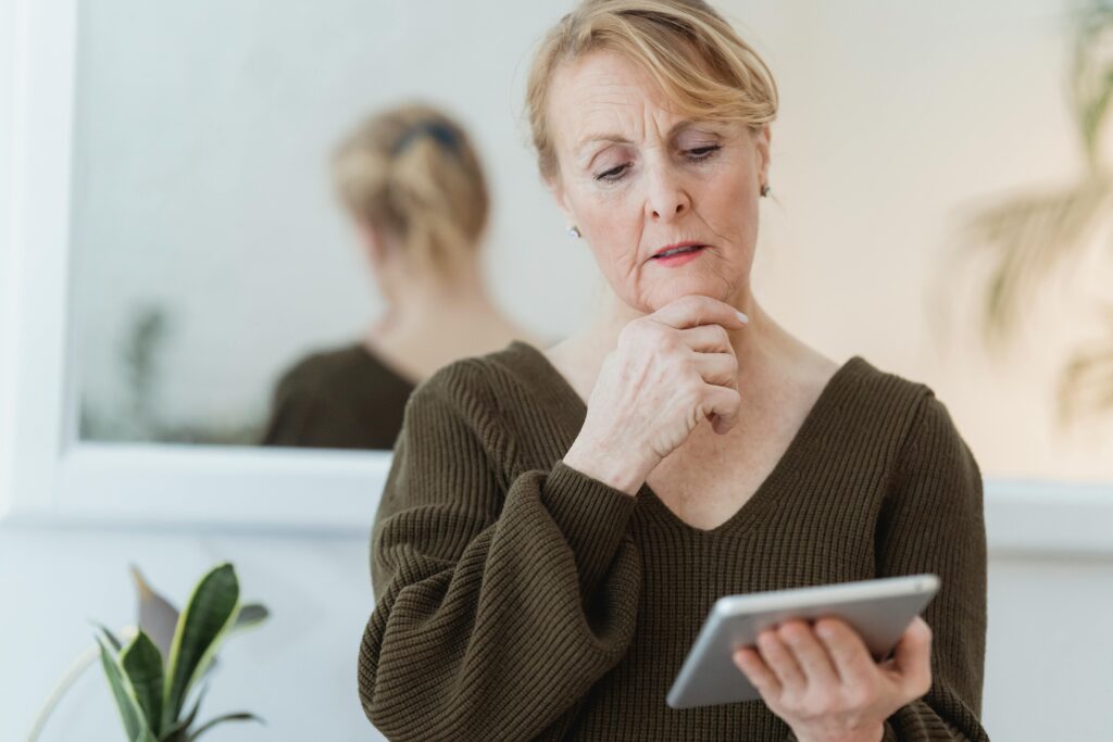 Senior Woman looking at a tablet and thinking
